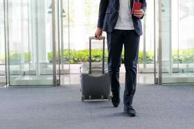 Foto: Mann mit Koffer am Flughafen